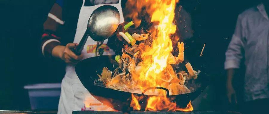 The cook is cooking in the fire